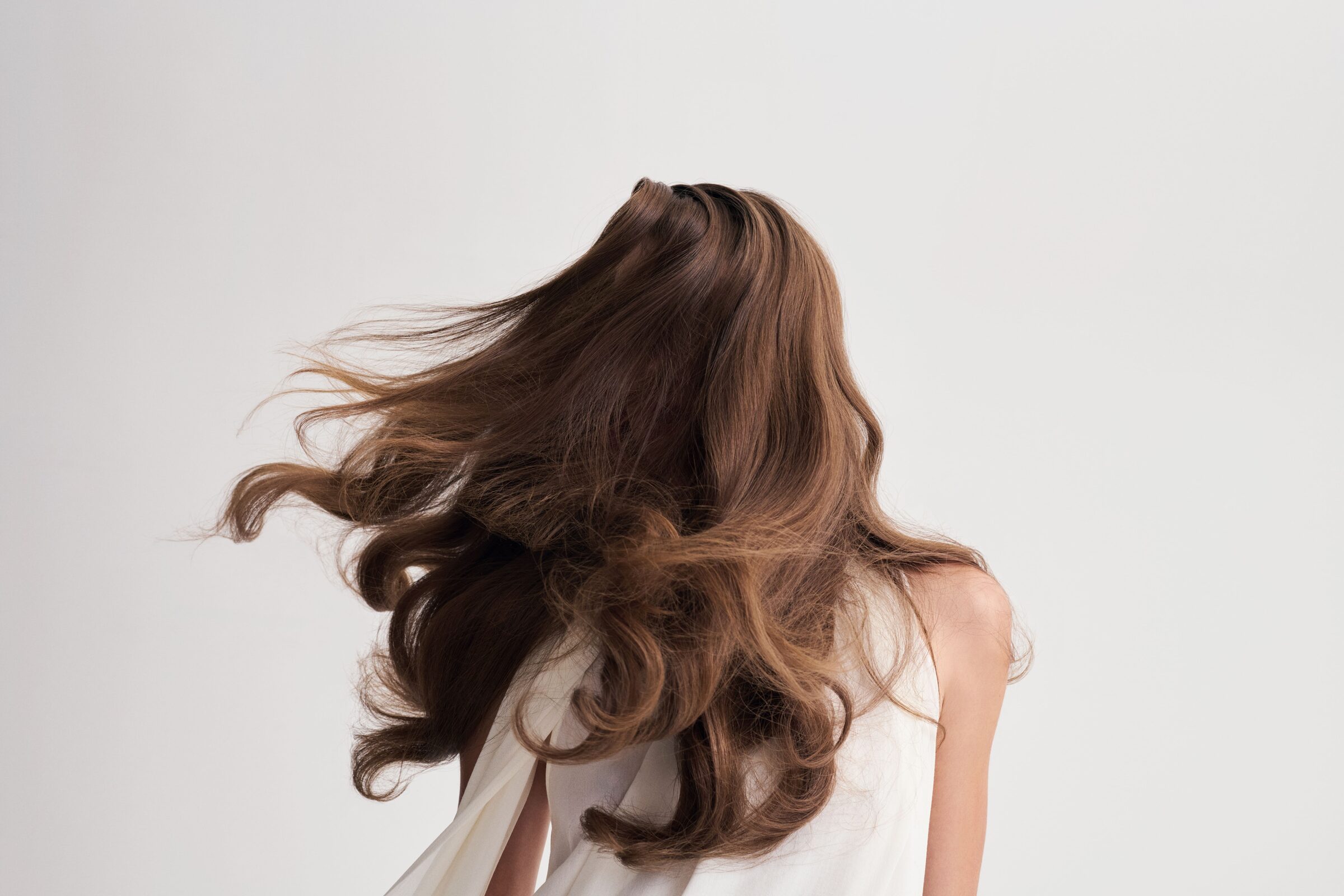 Capelli castani lunghi in movimento visti di spalle