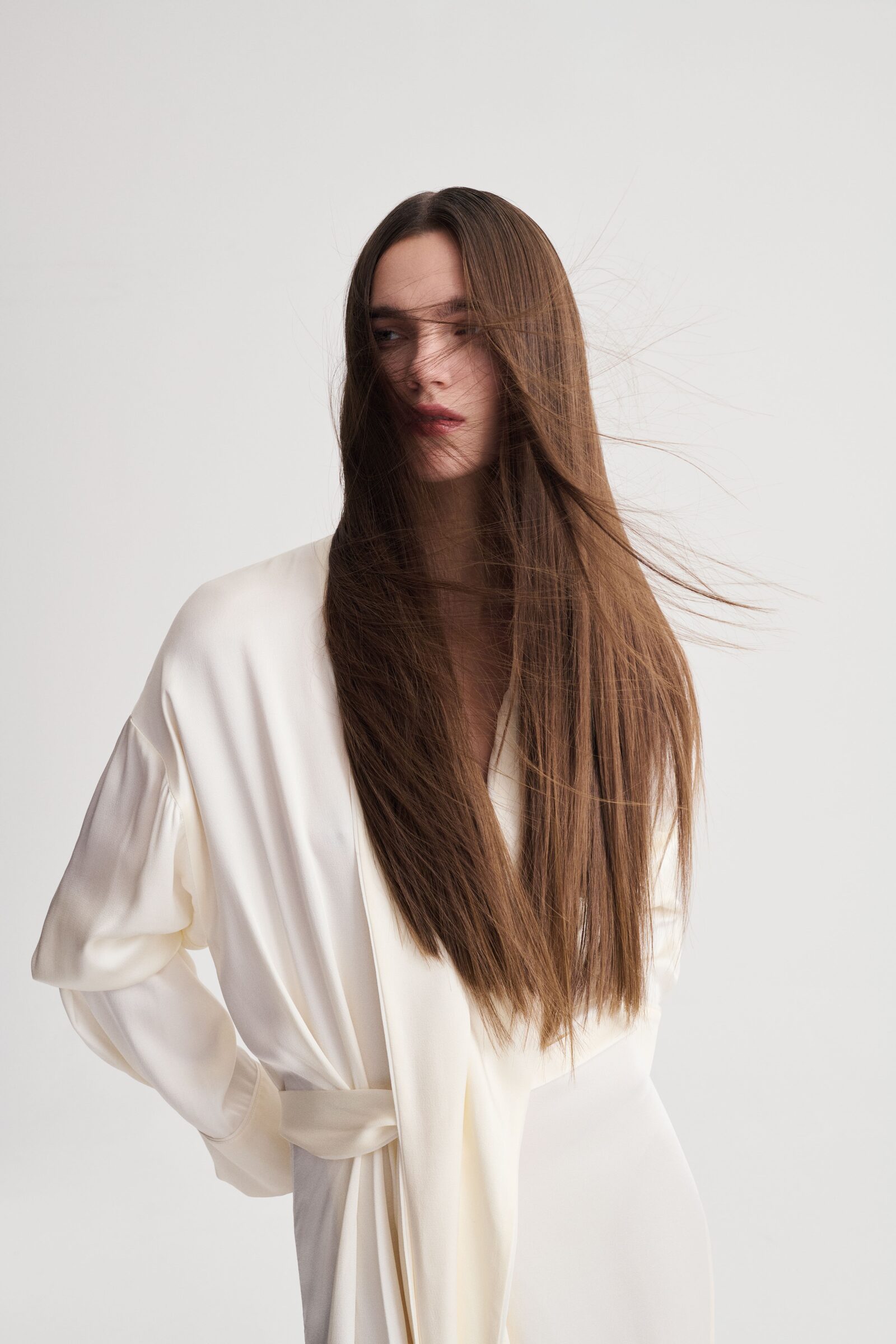 Modella in abito bianco con capelli lunghi e lisci